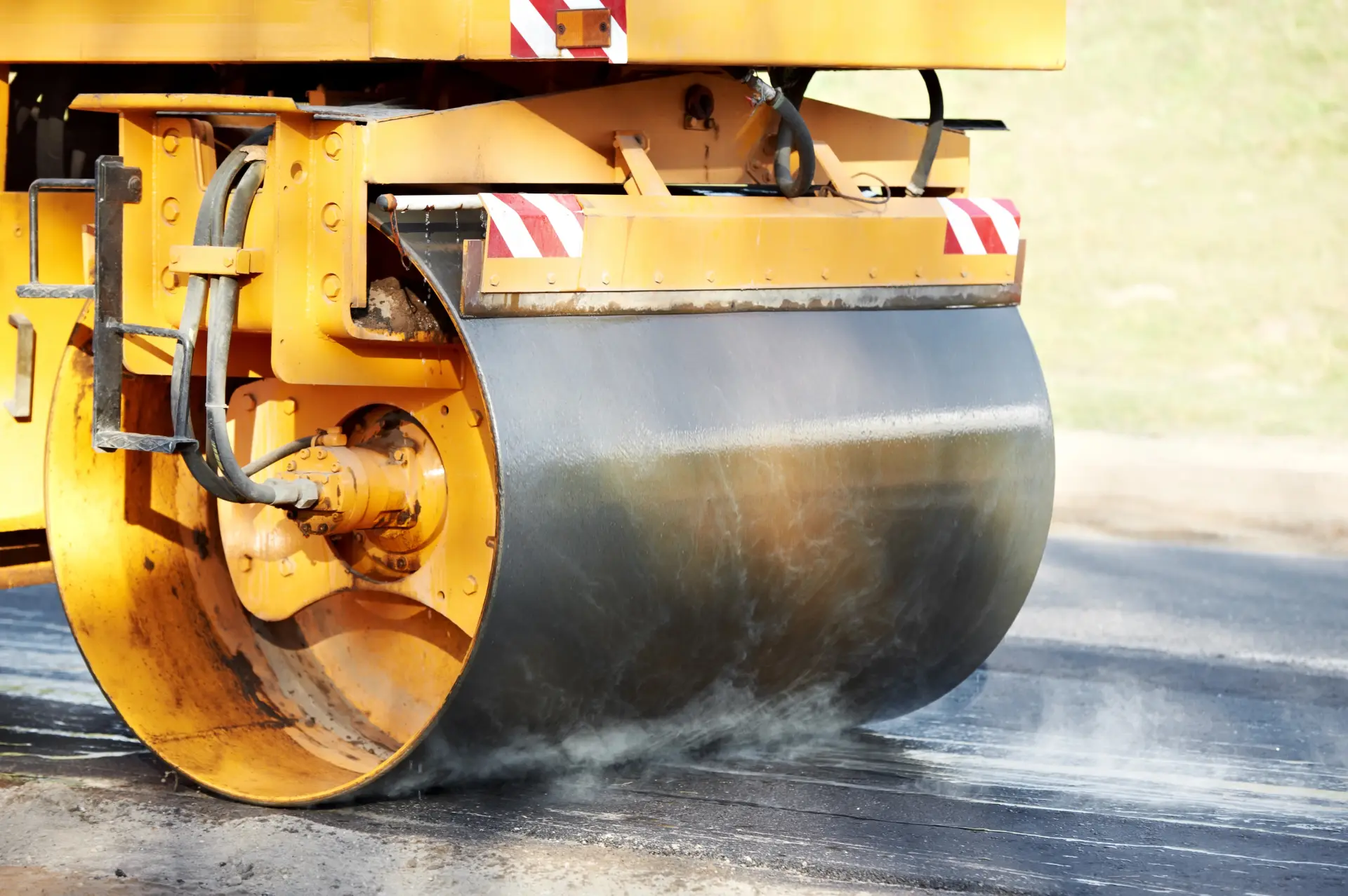Close up shot of an asphalt roller on fresh asphalt oil